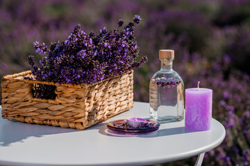 Obraz na płótnie Canvas Basket with beautiful lavender in the field in Provance with Lavander water and candles. Harvesting season