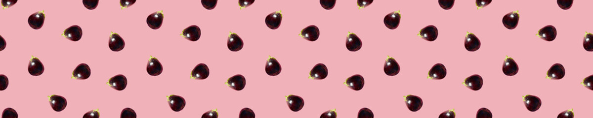 Seamless Eggplants Pattern on a pink background. Many Aubergines. Creative layout made of aubergines. Flat Food concept. Wallpaper. Backdrop. Banner