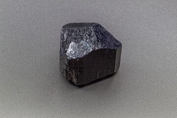 Macro focused black tourmaline schrol crystal isolated on gray background 