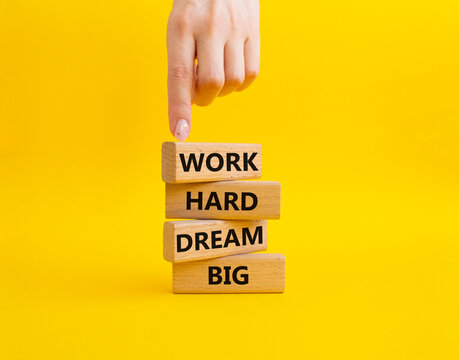 Work and dream symbol. Wooden blocks with words Work Hard Dream Big. Beautiful yellow background. Businessman hand. Business and Work Hard Dream Big concept. Copy space.
