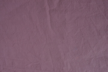 Textured fabric in the color of a dusty rose. Fabric background. Crumpled bed. Cotton texture. Calico bed sheet. Pink material. Home comfort. Textile industry.