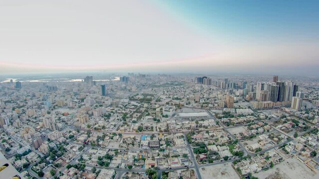 Panoramic cityscape of Ajman from rooftop from night to day transition timelapse before sunrise. Ajman is the capital of the emirate of Ajman in the United Arab Emirates.