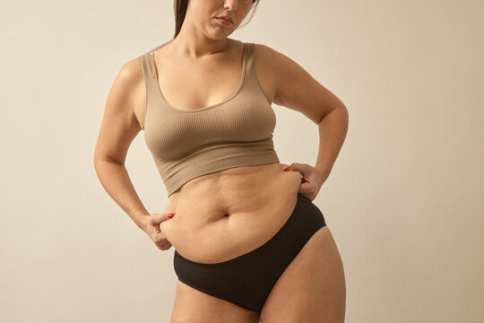unrecognizable woman pinch abdomen side fat. Body shaming problem, normalize woman body