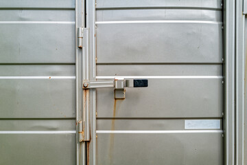 The latch on the rear door of a silver metallic horse trailer