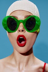 A large portrait of a shocked swimmer in a swimming cap on a blue background. Cool banner