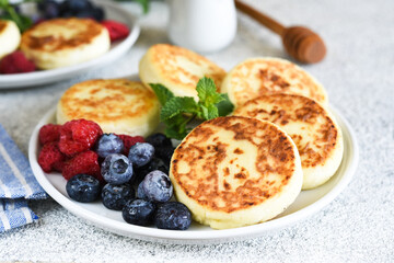 Cheesecakes with berries and sauce for breakfast.