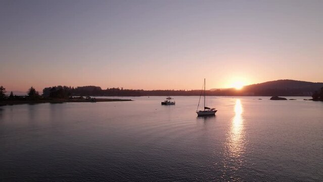 Aerial drone footage boats in harbour at sunset, Sooke BC, sail boats, marina, sunset sky. 5.4K TO 4K 24FPS.