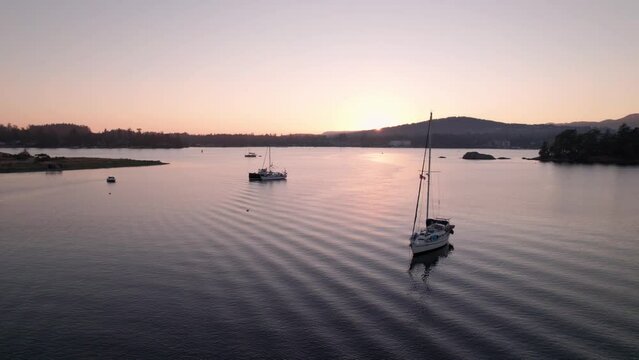 Aerial drone footage boats in harbour at sunset, Sooke BC, sail boats, marina, sunset sky. 5.4K TO 4K 24FPS.
