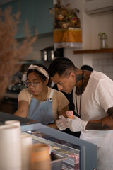Obraz premium Young handsome mexican tattooed man making ice cream in a cone.