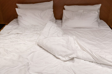 Crumpled linen on a large bed in a hotel