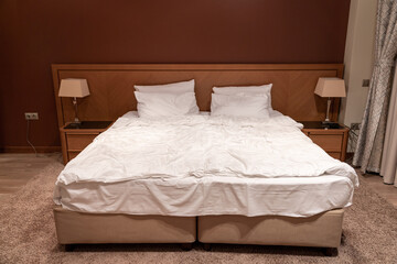 King size bed in hotel room with bedside tables and lamps