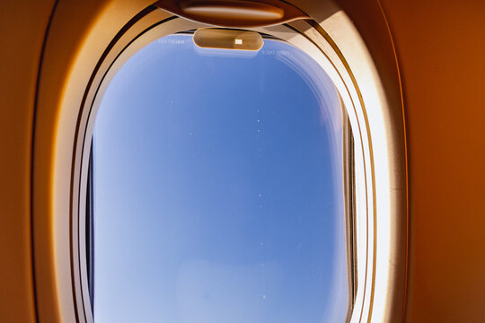 Plane window view with blue sky