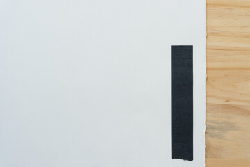 paper with black paper bar, torn edge, and wood