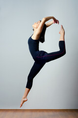 Young ballerina dancer jumping and dancing during workout in ballet studio