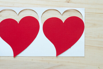 two grungy paper hearts and frame on wood