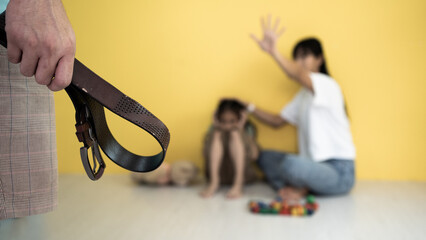 The girl is sitting in the room hiding from her abusive stepfather. The concept of raising children through domestic violence. Punishment for a crime with a belt. The problem of child abuse. - obrazy, fototapety, plakaty