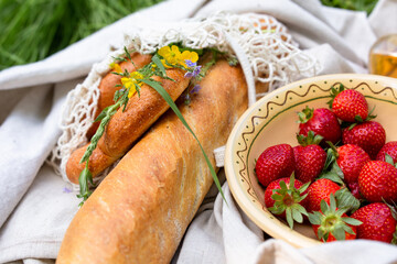 Picnic in the field with berries, juice, cheese, sausage and sweet croissants