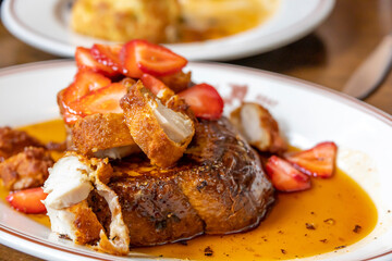 French toast with fried chicken and strawberries at a restaurant