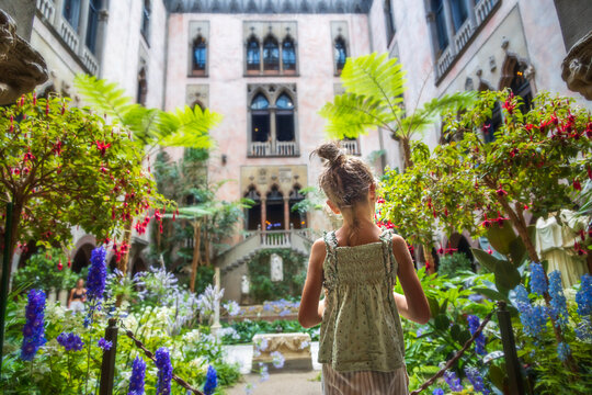 Little girl standing in front of a green garden in a building