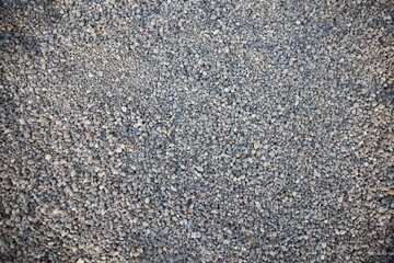 Pattern of small stones on the ground stoned beach gray stones
