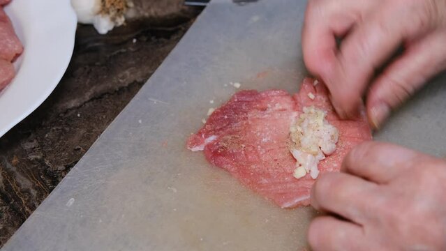 A delicious dish of pork mince wrapped with delicious pieces of bacon. Preparation of chevapchichi. Woman hands cooking meat rolls
