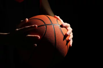 Foto op Plexiglas Basketball player with ball on black background, closeup © New Africa