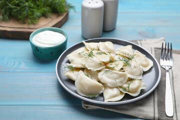 Delicious dumplings with dill on turquoise wooden table