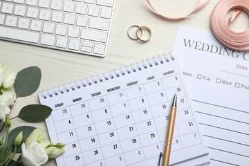 Flat lay composition with Wedding items and calendar on white wooden table