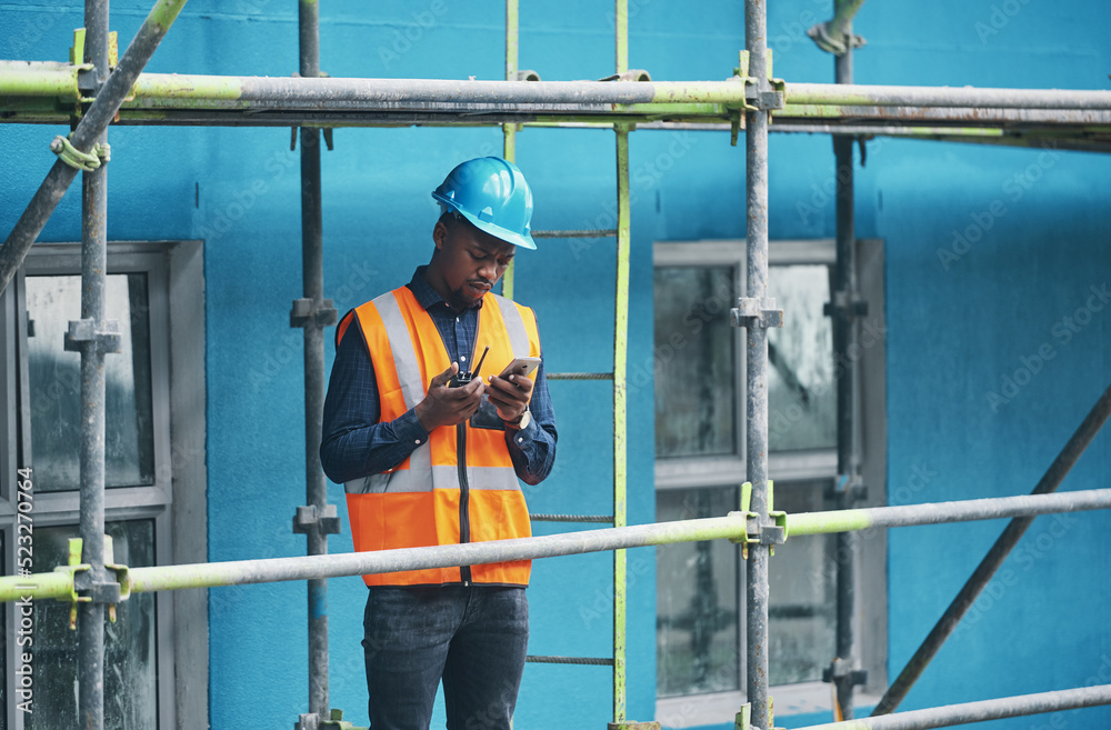 Poster male construction worker working checking a digital building plan on a phone. busy urban development