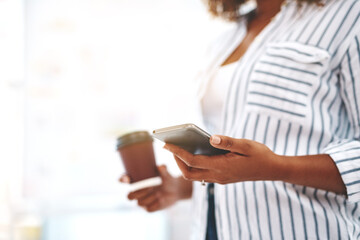 Creative checking social media on phone, texting or planning schedule while holding takeaway...