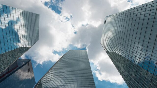 Business and finance concept. time lapse. view looking up at modern office building. Cloudy slow moving Beautiful Skyin the yeouido financial district, Seoul,South Korea.(zoom in)