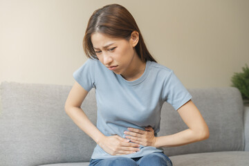 Flatulence asian young woman hand in stomach ache, suffer from food poisoning, abdominal pain and...