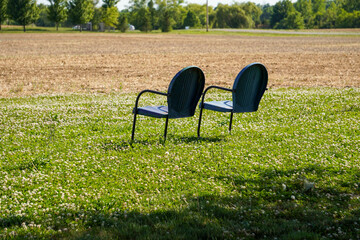 Lawn chairs on the side of a farm field