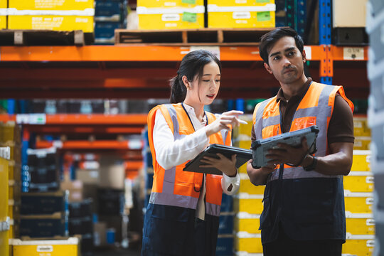 Warehouse worker and manager checks stock and inventory with using digital tablet computer in the retail warehouse full of shelves with goods. Working in logistics, Distribution center.