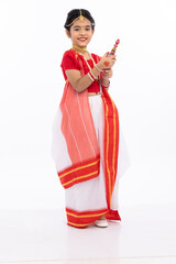 Portrait of beautiful bengali girl in traditional sari holding sindoor dani
