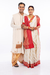 Portrait of happy bengali couple in traditional clothing on occasion of durga puja celebration
