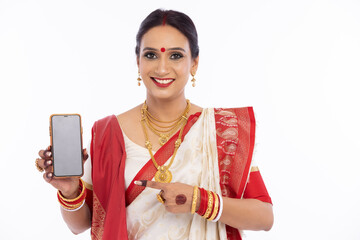 Happy bengali woman in traditional sari showing mobile phone screen
