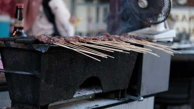 Several grilled skewers are being burned