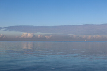 calm ocean waves and cloud reflections and sky