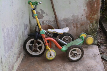 a child's shabby bicycle parked on the terrace of the house