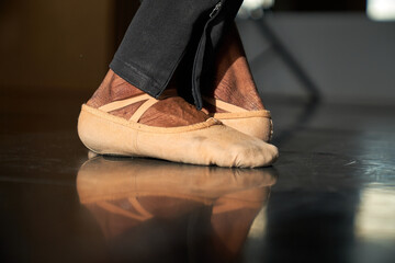 Feet of a professional ballet dancer in a warm-up before rehearsal