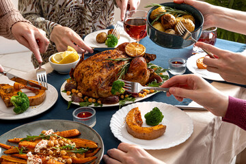 People celebrating Thanksgiving Day. Thanksgiving party table setting. Traditional holiday stuffed baked chicken dinner and vegetable. Family party or gathering.