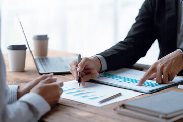 Close-up of a group of business meeting to discuss plan analyze graph and chart and calculate company performance, balance sheet, financial statement, income statement and deficit.