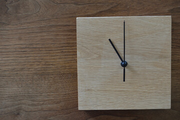 11時をしめすシンプルな木製の掛け時計