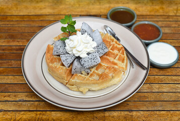 Belgium waffles with dragon fruit and ice cream on a plate