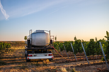 water trailer with hoses in a vineyard