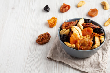 Organic healthy fruit mix in a bowl, side view. Copy space.