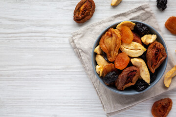 Organic healthy fruit mix in a bowl, top view. Flat lay, overhead, from above. Copy space.