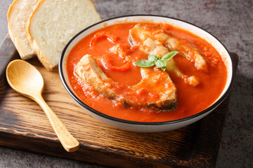 Fishermans soup or halaszle is a hot, spicy paprika based fish soup closeup in the bowl on the wooden tray. Horizontal