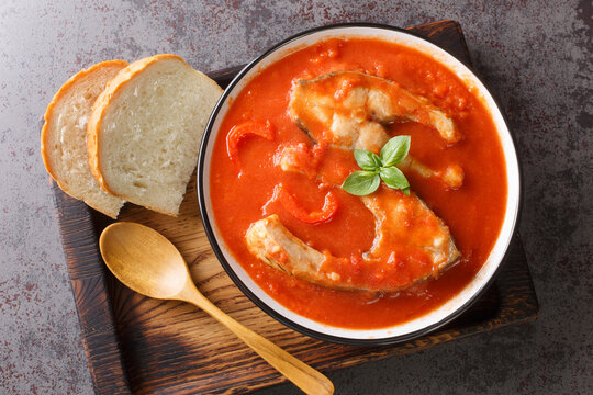Thick hearty Soup with carp steak, vegetables and paprika close-up in a bowl on the table. Horizontal top view from above
